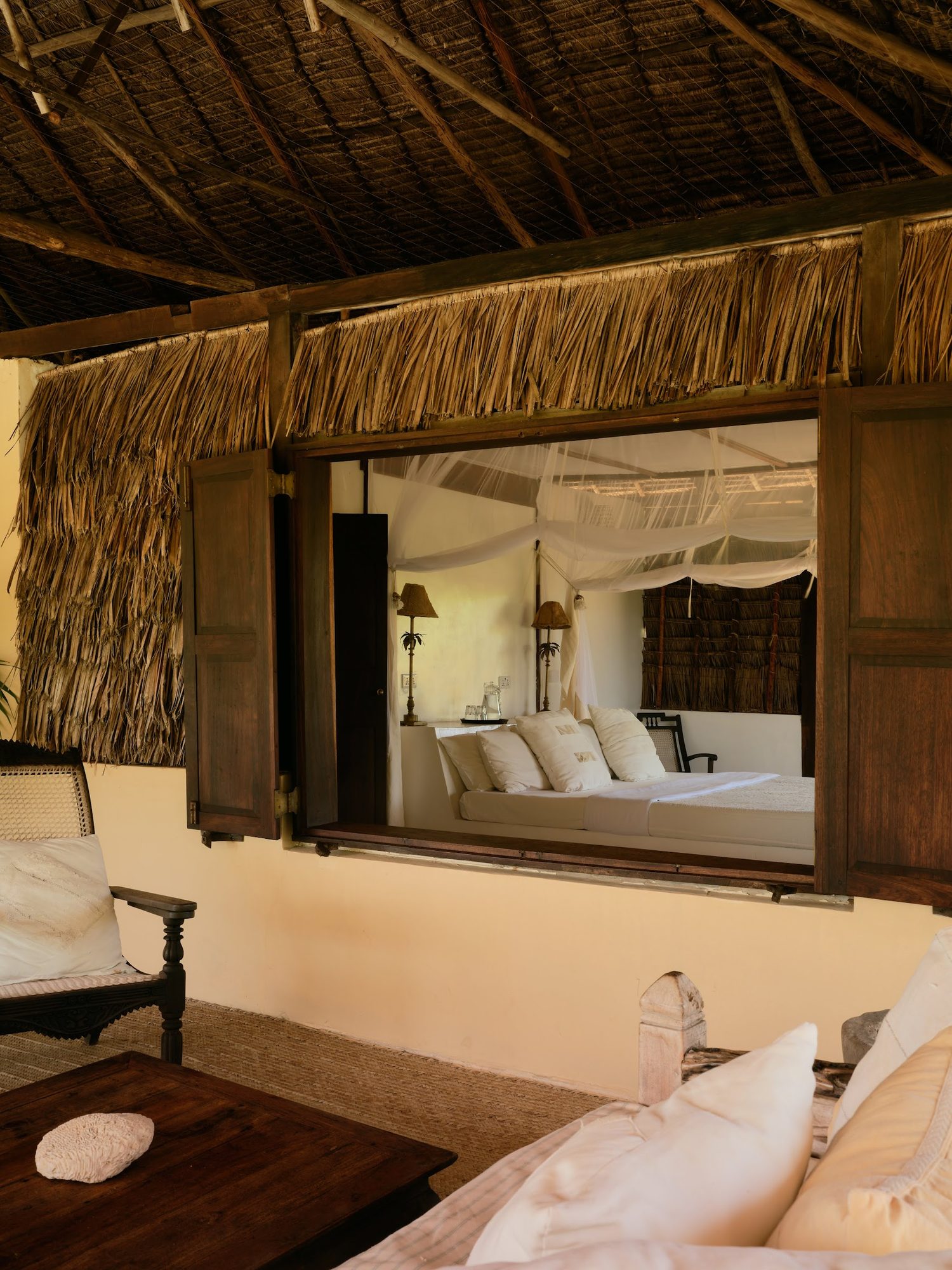 The coral stone colonnade and lime-plaster archways at The Cabanas Lamu