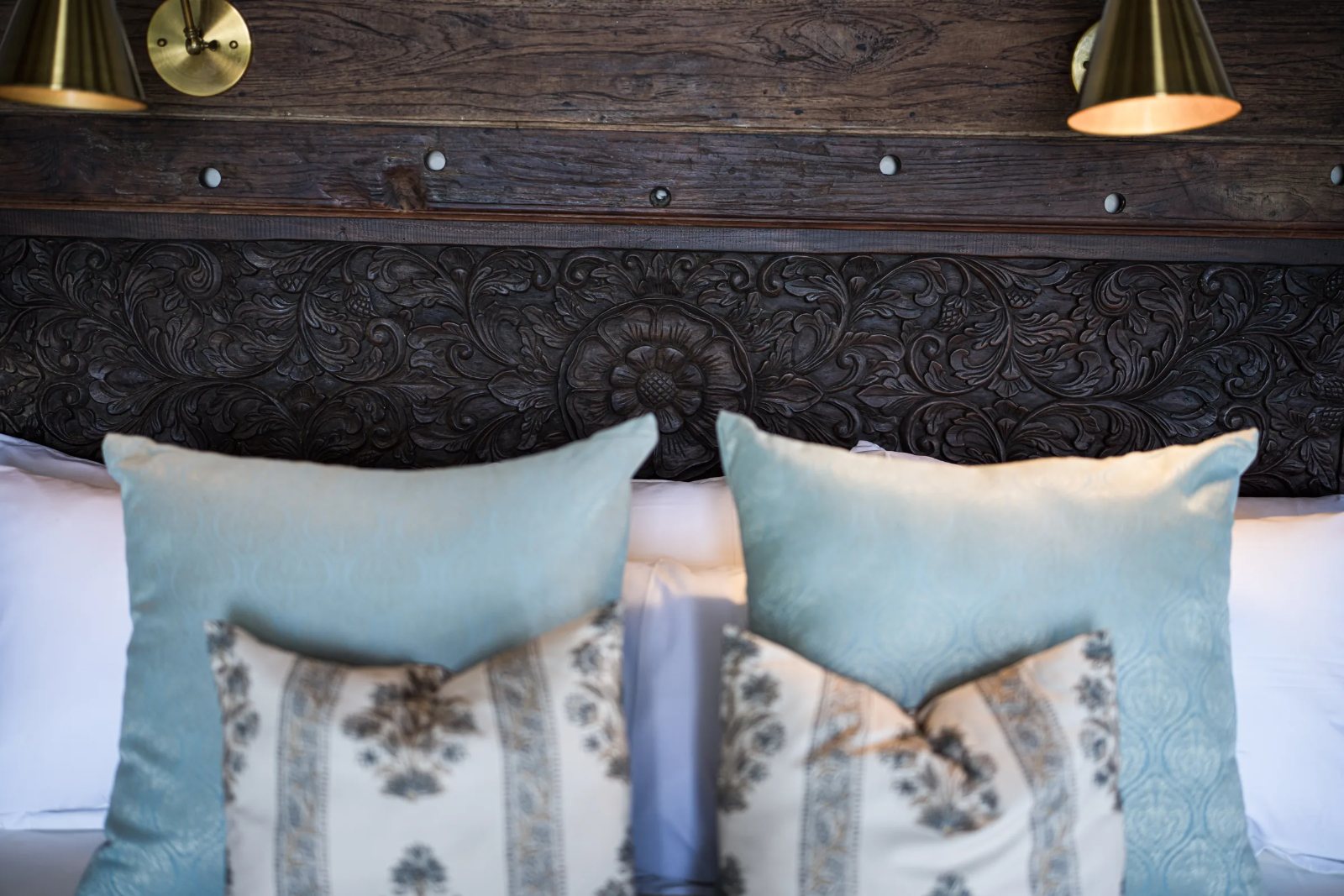 Aloha cabana · hand-carved headboard, brass lamps and block-printed cushions