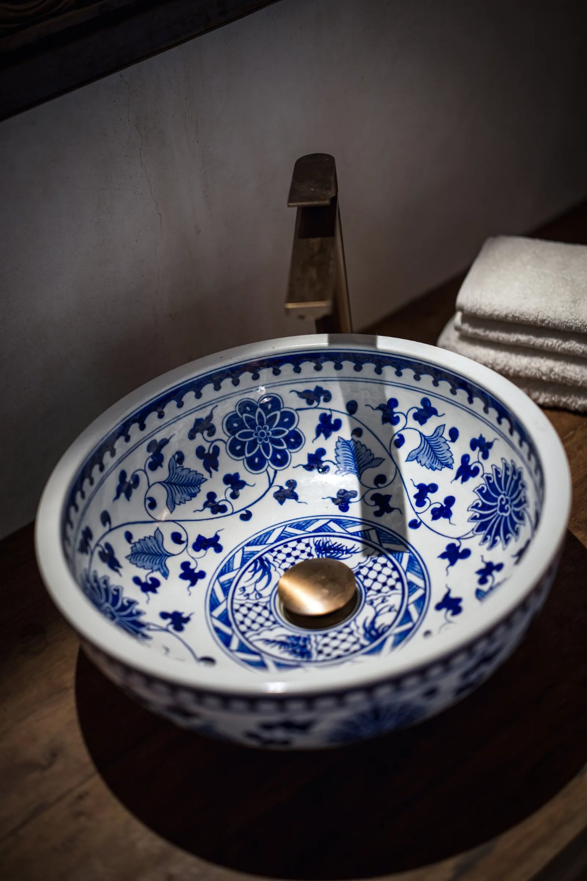 Aloha cabana · blue-and-white porcelain basin with a brass tap in the ensuite