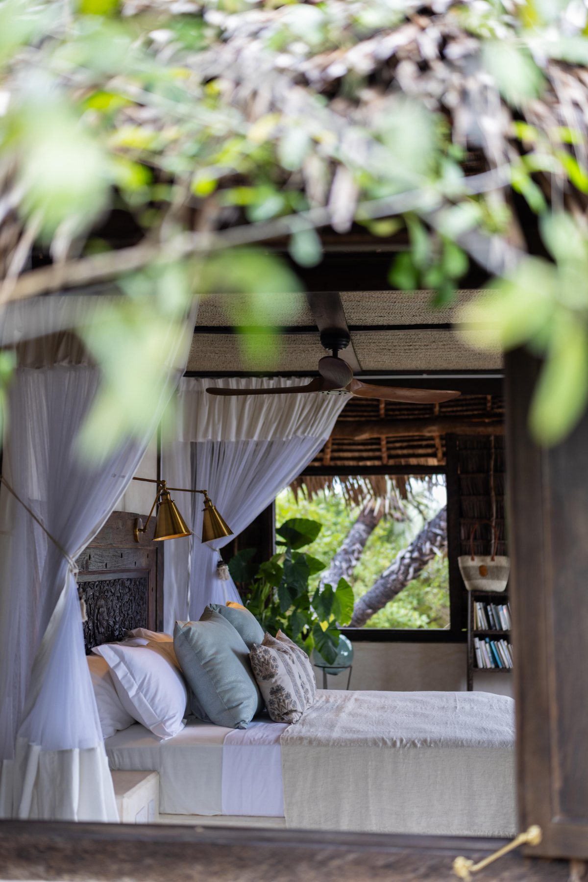 Aloha cabana · looking through the trees to the bed, ceiling fan and reading nook