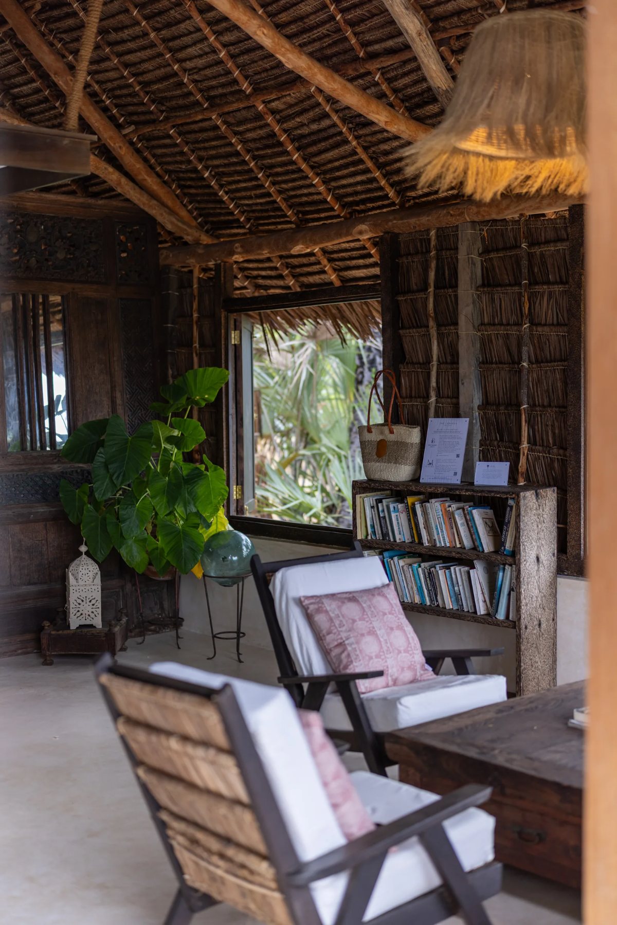 Aloha cabana · the lounge under makuti thatch, with bookshelf, lanterns and deck chairs
