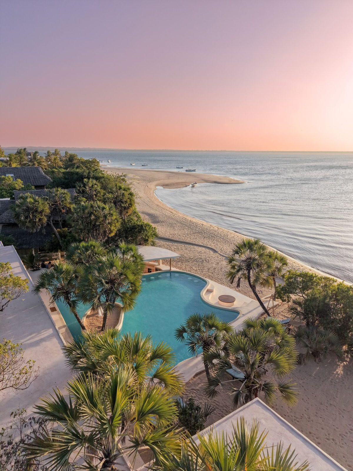 Aerial view of The Cabanas Lamu at golden hour — pool, palm-shaded beach and dhows on Kizingoni Beach, Lamu Island