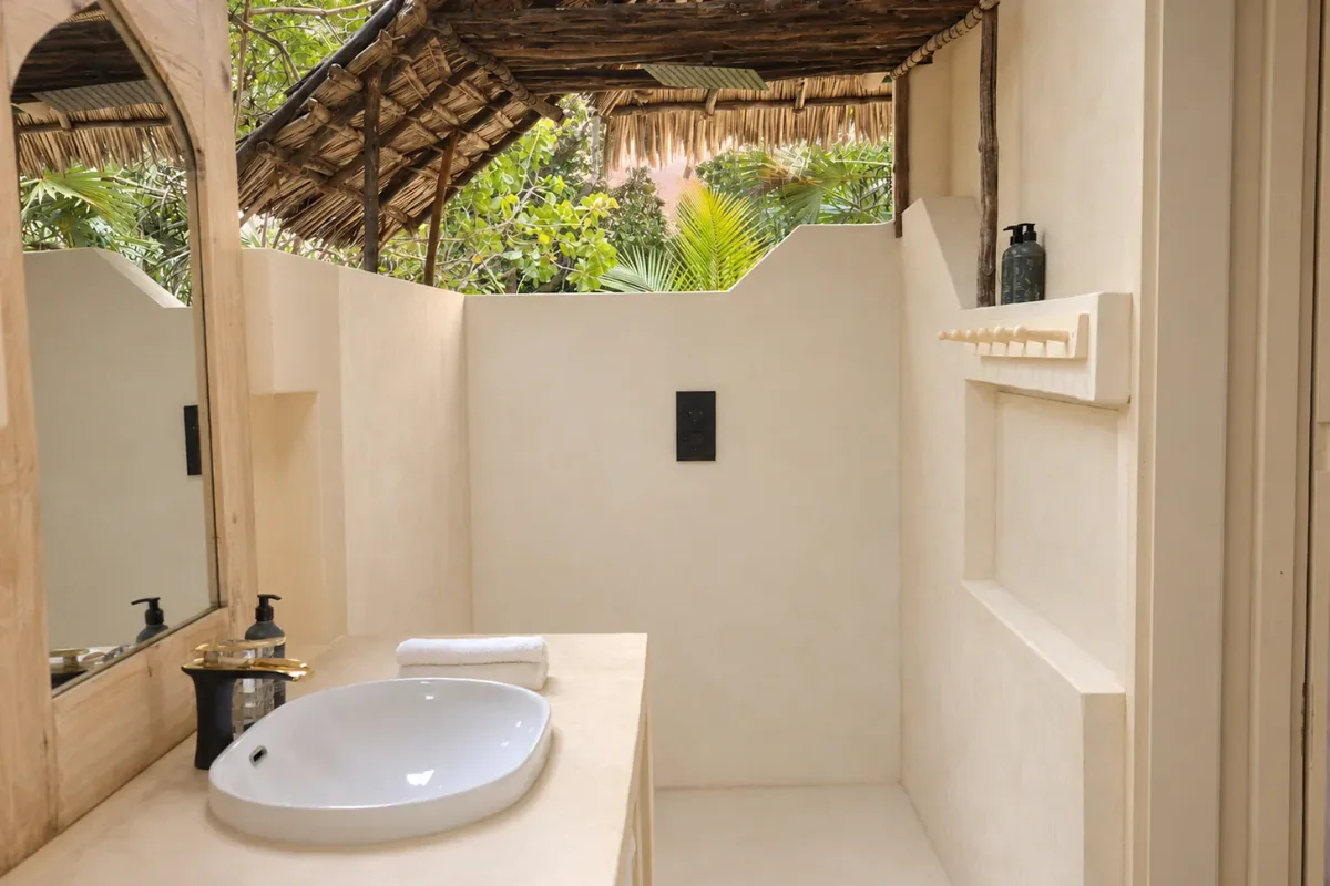 Makai ground-floor bathroom, open to the sky with the trees above the walls