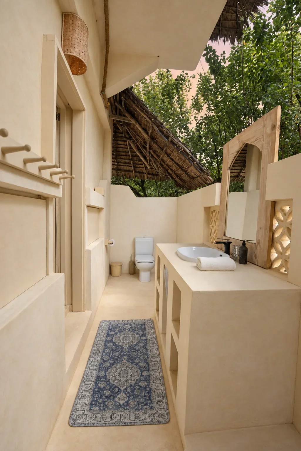 Makai ground-floor bathroom, a long open-air room with a stone vanity and arched mirror