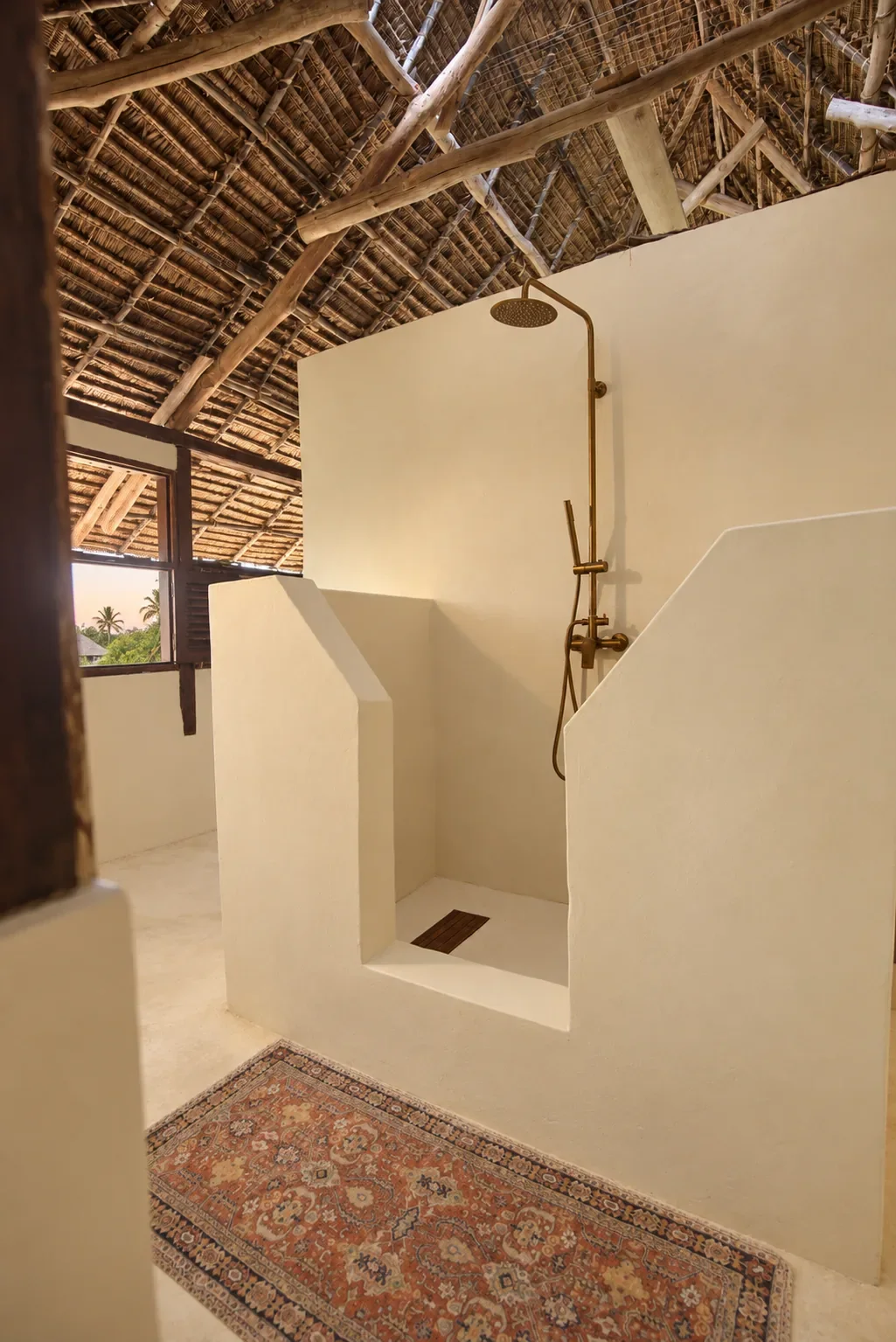 Makai first-floor walk-in shower, brass fittings under the makuti thatch