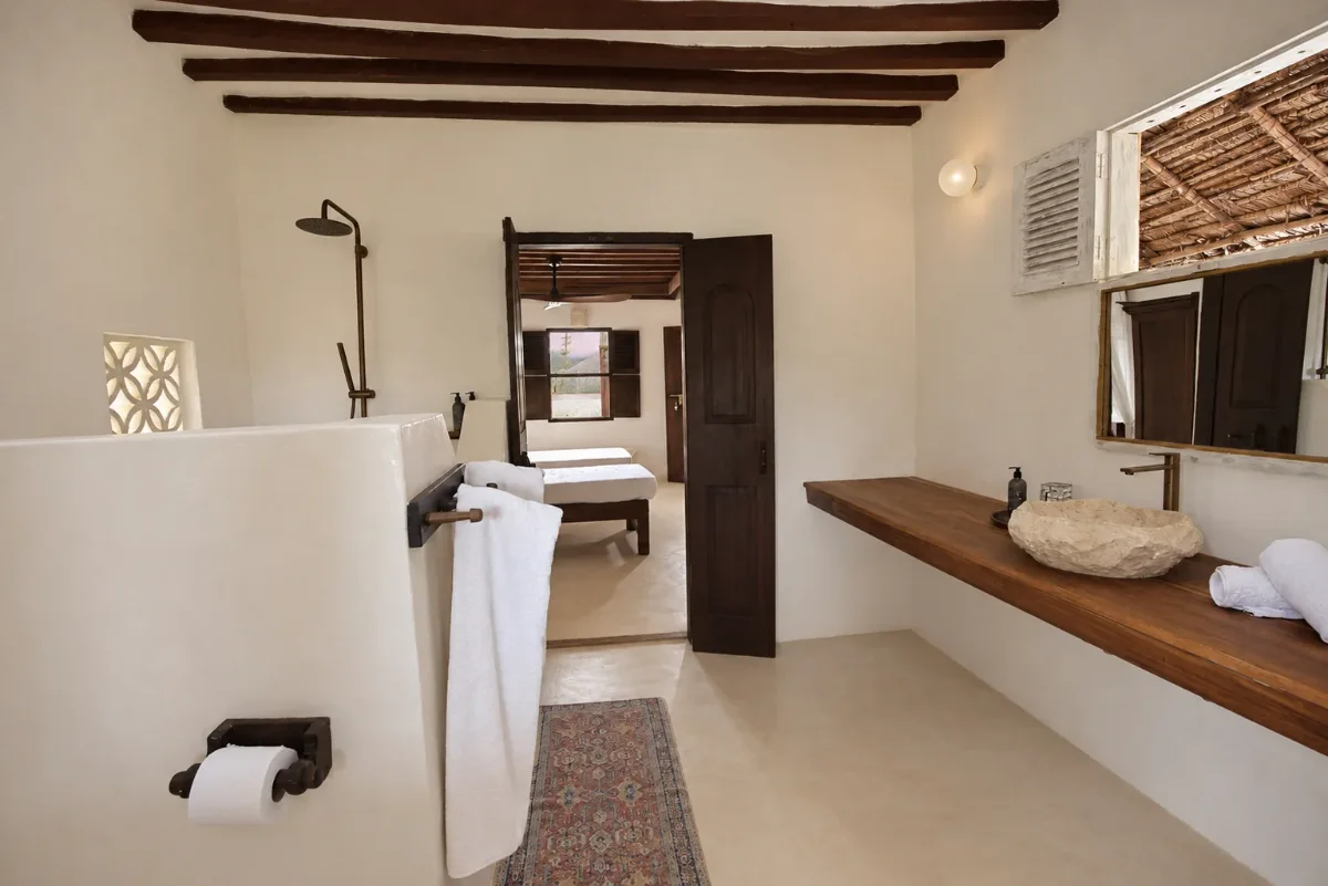 Mālama ground-floor ensuite, open shower, stone basin on a timber counter