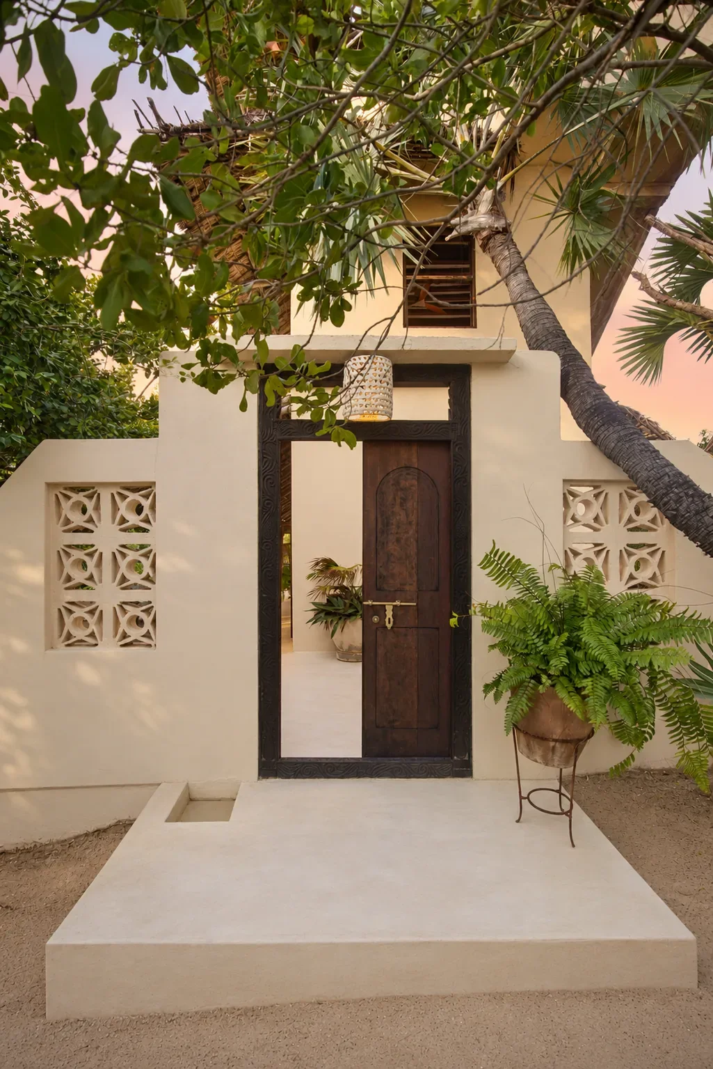 Mālama cabana, the carved Lamu door and coral-stone entrance at dusk