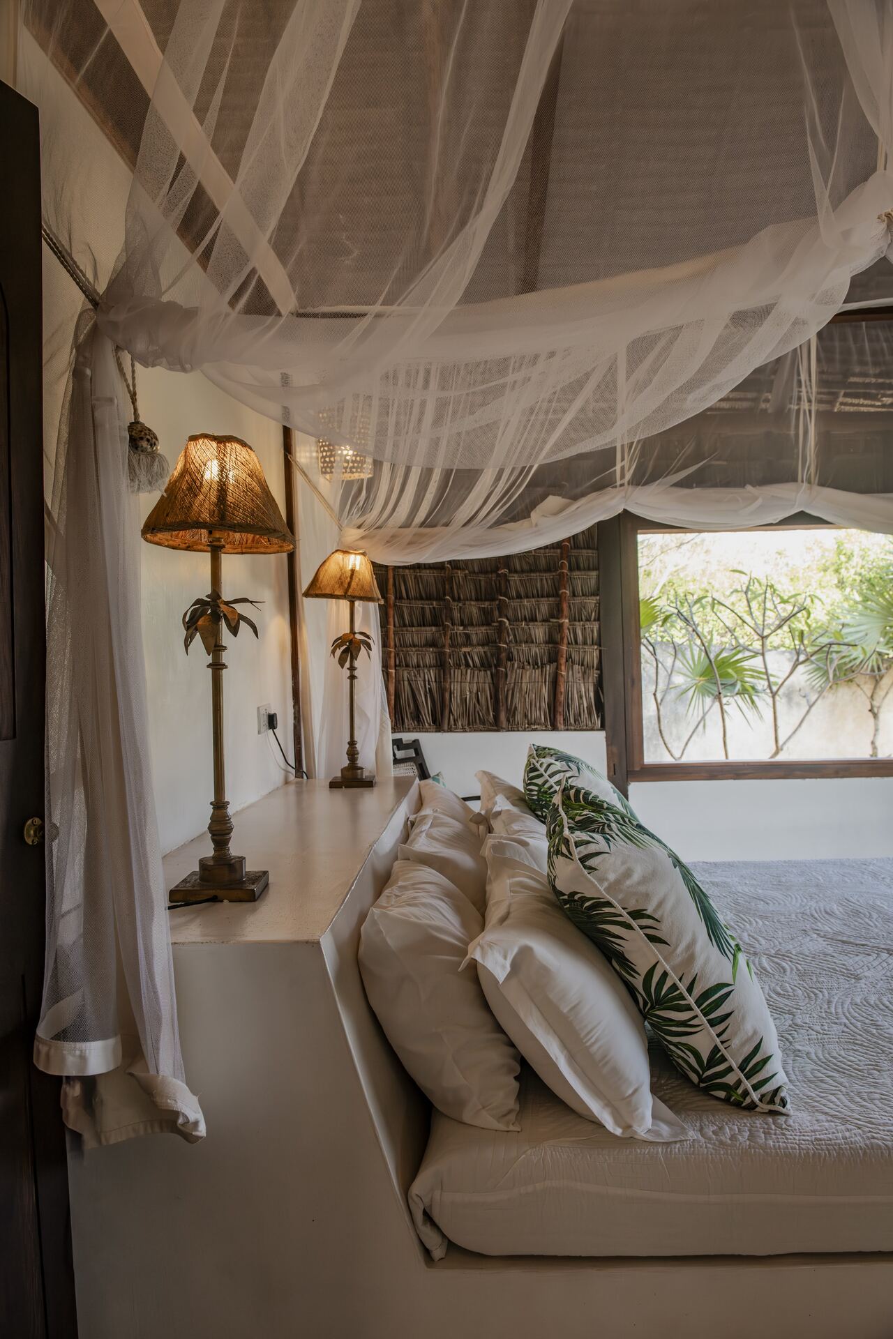 ʻOhana cabana — daybed lounge under makuti palm-thatch shade