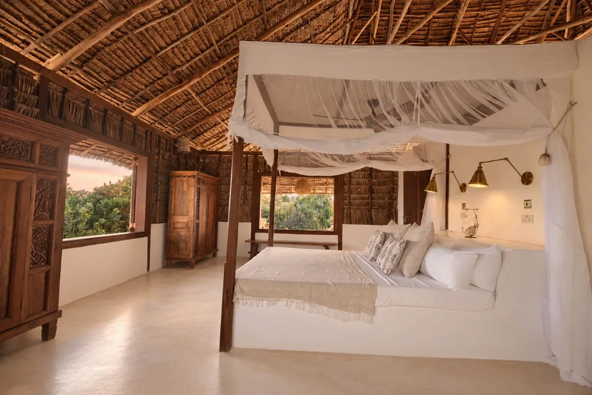 ʻOhana cabana, netted double bed with brass lamps and carved wardrobes